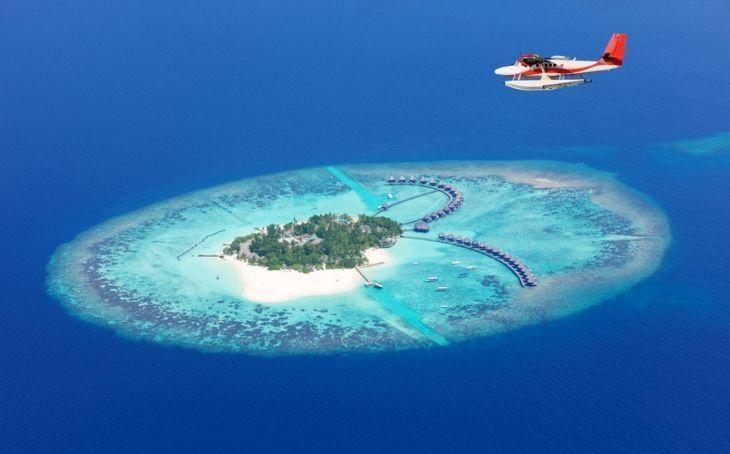 Sea plane flying above Maldives islands, Raa atol