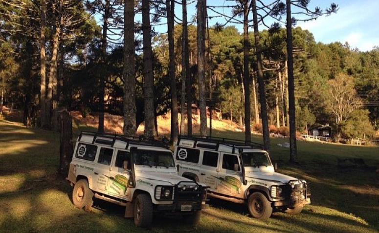 Dois jipes brancos dentro de um campo em Monte Verde