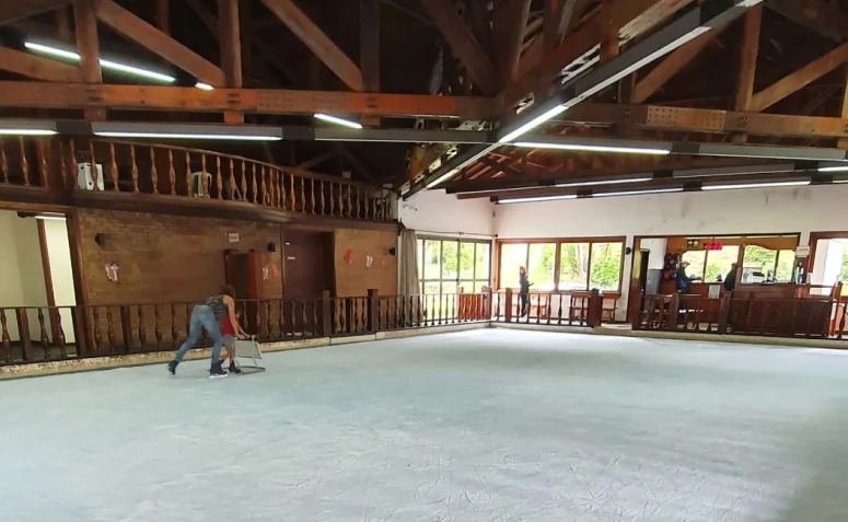 Uma pessoa adulta e uma criança em uma pista de patinação em Monte Verde