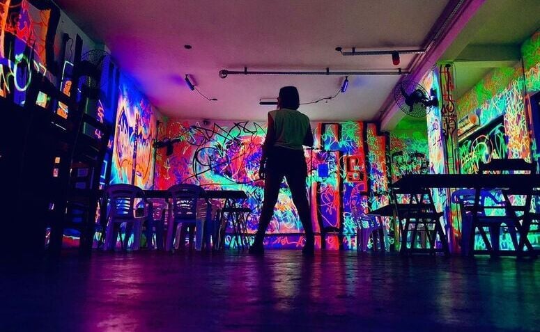 Interior da balada BOMBARRV de Salvador, com paredes com grafismos em neon